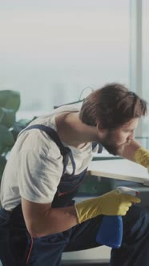 Worker Sanitizes Office Surface Carefully Person with Protective Gear Disinfects Modern Office