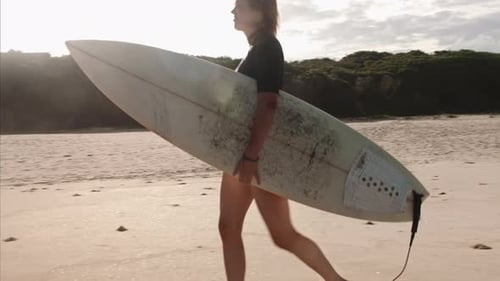 Wide Shot Of Beautiful Independent Surfer Girl Walking On The Beach With Surfboard In Search Of E...