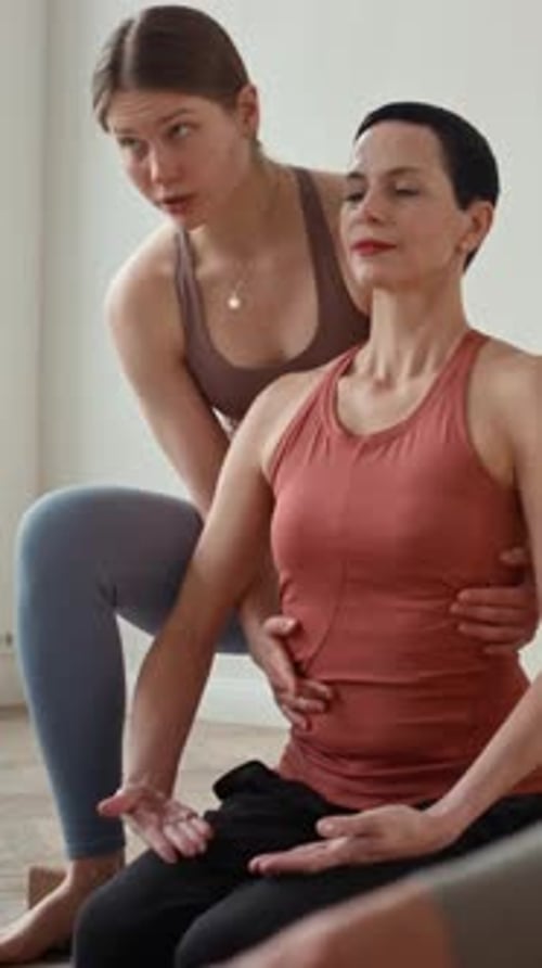 Instructor Aligning Yoga Posture