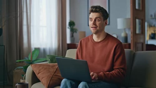Man Using Laptop Computer at Home on Couch