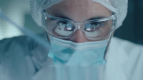 Scientist Adds Liquid To Test Tubes in Lab