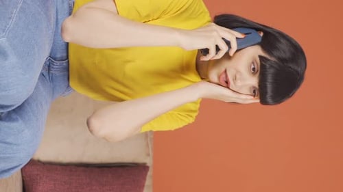 Vertical video of Young woman getting bad news on the phone gets upset.