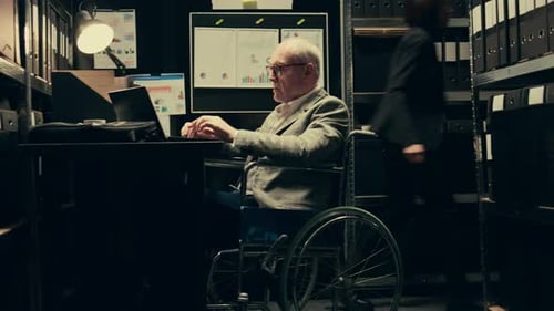 Disabled Senior Working with Colleague in Office