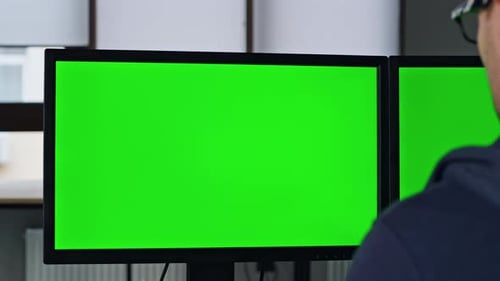 Zwei grüne PC-Monitore in Büro-Nahaufnahme. Professioneller Designer, Manager, arbeitet mit Chromakey