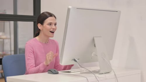 Excited Woman Celebrating Online Success at Computer
