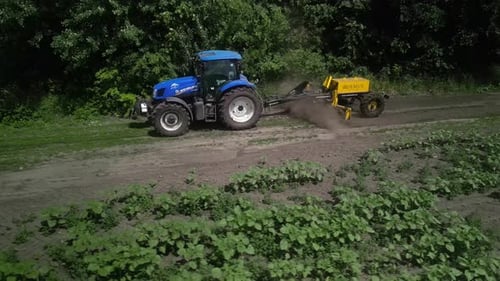 Der Grader arbeitet mit dem Traktor und ebnet die Feldstraße