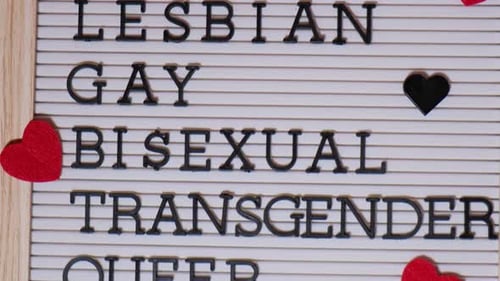 LGBTQIA+ Words on Wooden Sign with Hearts