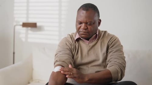 Portrait of Middleaged Man Unpacking and Sticking Nicotine Patch on Arm Innovative Transdermal Patch