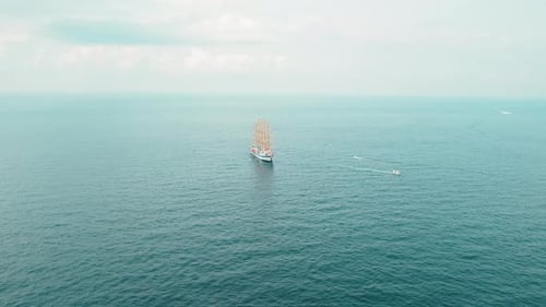 Segelschiff auf offener See mit ein paar kleineren Booten in der Nähe. Luftaufnahme des Wassertransports.