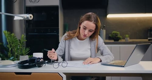 Female marketing manager sitting the table and working with financial and marketing documents