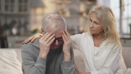 Worried Man Comforted by Supportive Woman Indoors