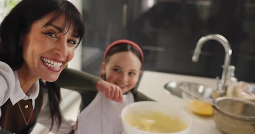 Smiling Woman and Child Baking Together in Kitchen
