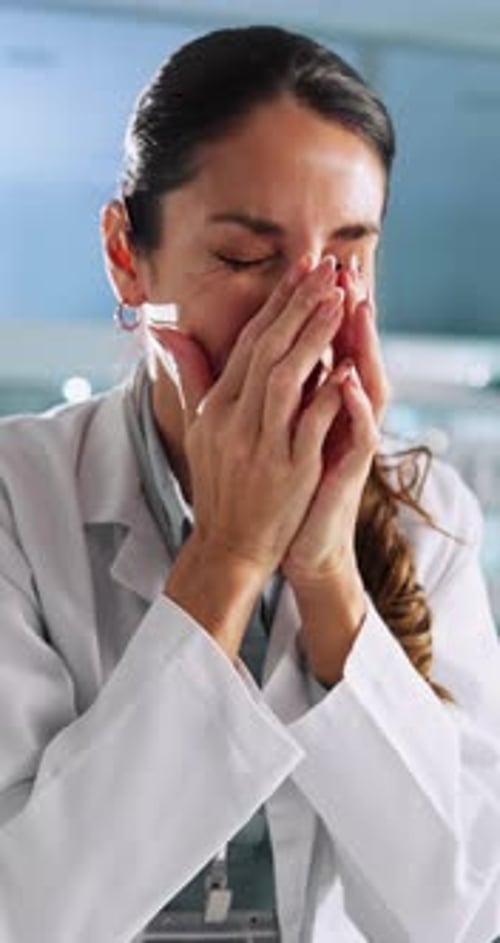 Stressed Woman in Doctor's Coat Rubbing Eyes