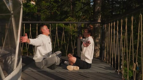 Partners Do Yoga Spreading Arms at Glamping