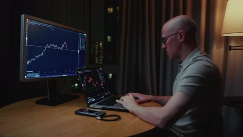 Man Stock Trader in Home Office Male Analyzes Terminal Trades Stocks on Crypto Market Candlestick