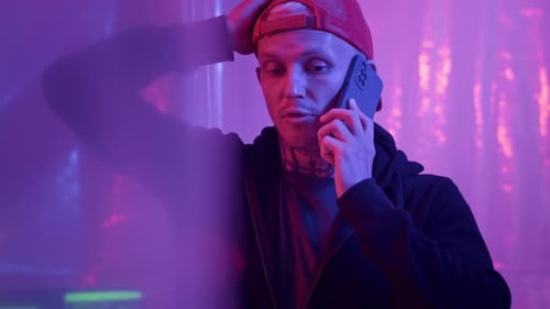 Man Talking on Phone in Purple and Blue Light