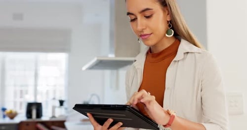 Woman uses Tablet in Modern Kitchen