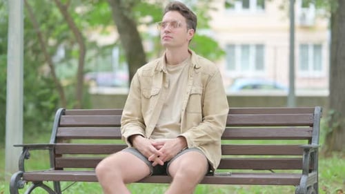 Man Sitting Thoughtfully on Park Bench