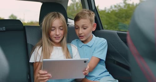 Children Using Tablet in Back Seat of Car