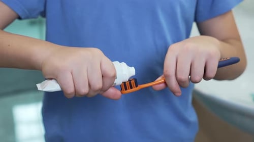 Boy Squeezing Toothpaste on Brush
