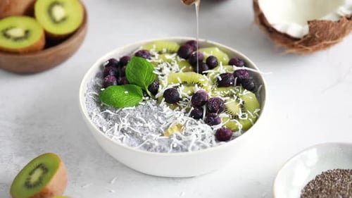 Drizzling Honey on Fruity Chia Seed Pudding Bowl