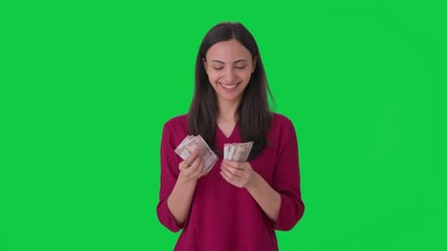 Happy Indian woman counting money Green screen