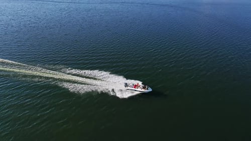 Motorboat on blue water surface. Tourists travel in a high-speed boat in the sea.