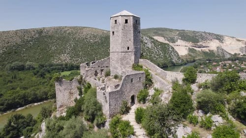 Aerial rising castle ruins citadel Počitelj in the Balkans on a sunny summer day