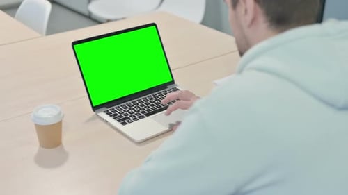 Young Man Using Laptop with Green Screen