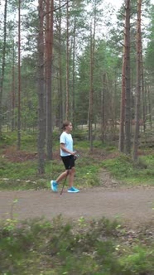 Active Woman Doing Nordic Walking in a Park