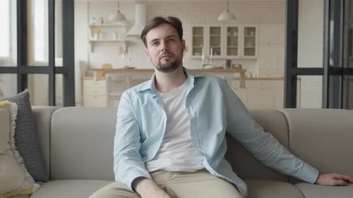 Man Relaxing on Couch Watching Television