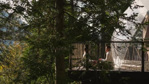 Couple Relaxing on Deck of Dome in Forest