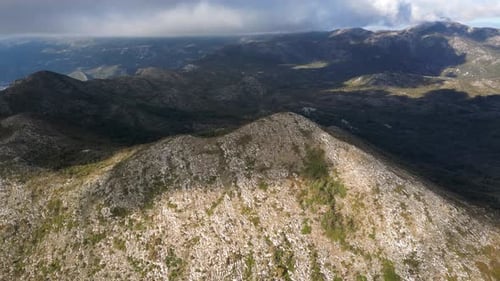 A mountain peak is illuminated by the sun. Mountain landscape filmed with a drone. Aerial view.