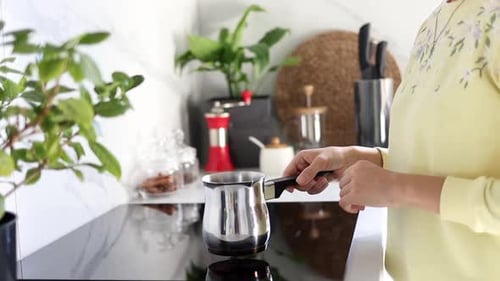 Woman Prepares Coffee in a Modern Kitchen