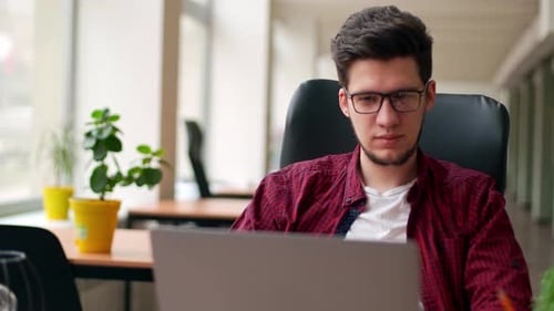Young Adult Working at Computer in Modern Office