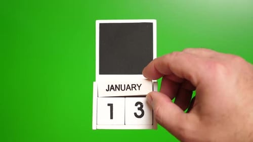 Hand Changing Date on Calendar to January 13