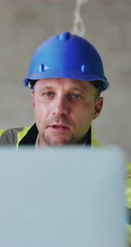Construction, talking and man on laptop in building for planning, research and online blueprints