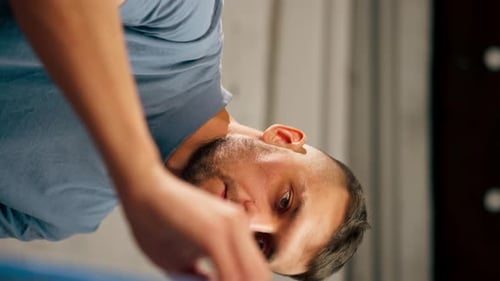 Vertical Video Closeup of a Young Artist in Blue Tshirt in an Art Studio Working on a Painting
