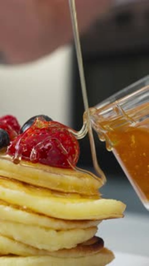 Vertical Of Pancakes Topped With Syrup And Fresh Strawberries. Close-up Shot