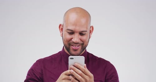 Man Smiling and Looking at Smartphone