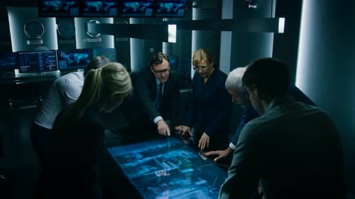 Team Collaborating Around Interactive Table in Dark Room