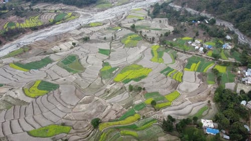 An aerial view of the terraced fields on a hillside farming community in Nepal.