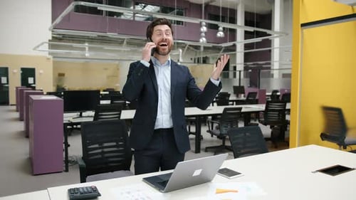 Smiling Man in Suit Talking on Cell Phone in Office