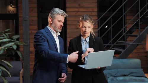Business Professionals Discussing Work on Laptop Indoors