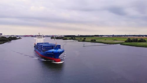 Container Ship Transporting Bulk Of Intermodal Across The River. - aerial
