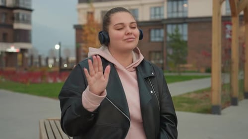 Joyful Woman Dancing in Urban Outdoor Setting with Blinking Distant Lights