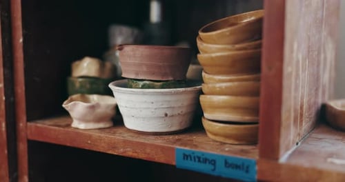 Various Mixing Bowls Stacked on Wooden Shelves