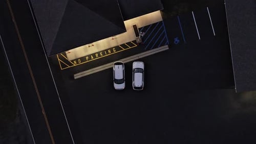 Overhead descending Birdseye view of cars parked
