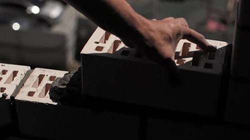 Man Laying Bricks at a Construction Site Closeup