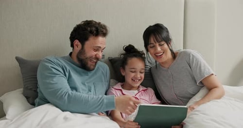 Family Using a Tablet Together in Bed